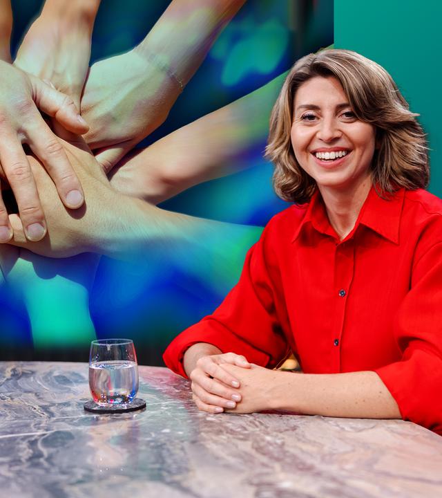 die Moderatorin Stephanie Rohde im Studio an einem Tisch, im Hintergrund ein Foto mit sich umfassenden Händen