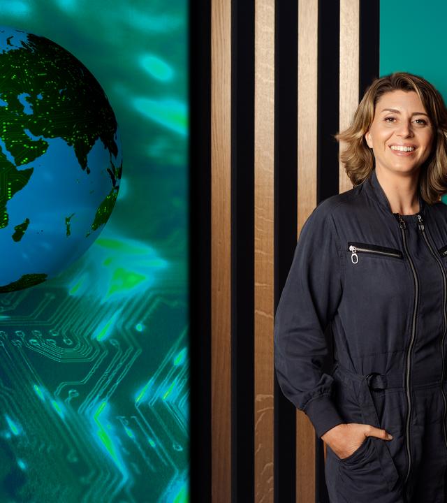 Die Moderatorin und ein Gast, im Hintergrund Studio-Holz-Lamellenwand und eine Erdkugel mit digitalen Leuchtspuren