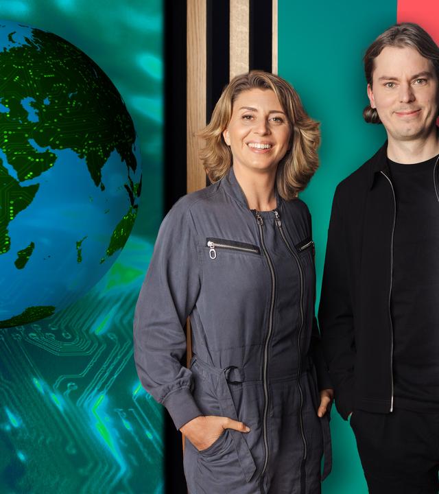 Die Moderatorin und ein Gast, im Hintergrund Studio-Holz-Lamellenwand und eine Erdkugel mit digitalen Leuchtspuren