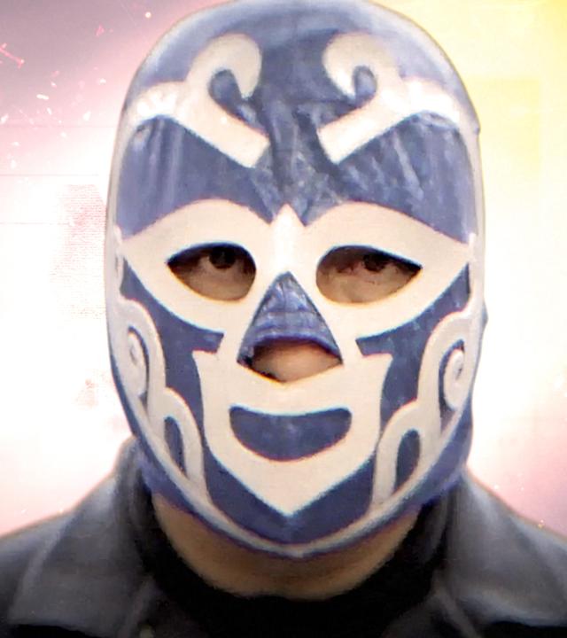 Montage: Ein Mann trägt eine blau-weiße Luchador-Maske und schaut in die Kamera. Im Hintergrund brennt ein Feuer in der Nacht, Funken sprühen.