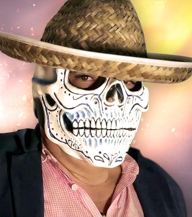 Montage: Ein Mann trägt eine mexikanische Totenmaske und einen Hut und blickt in die Kamera. Im Hintergrund brennt ein Feuer in der Nacht, Funken sprühen.