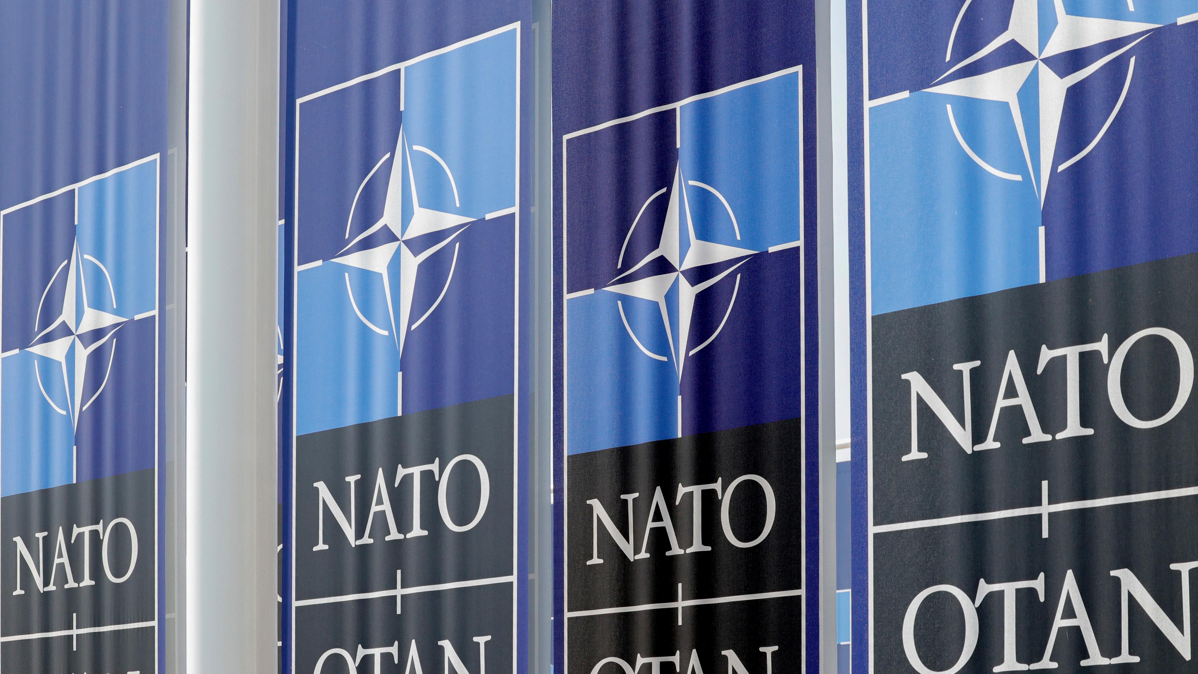 Das Bild zeigt Banner mit dem Bündnis-Logo vor dem Nato-Hauptquartier in Brüssel.