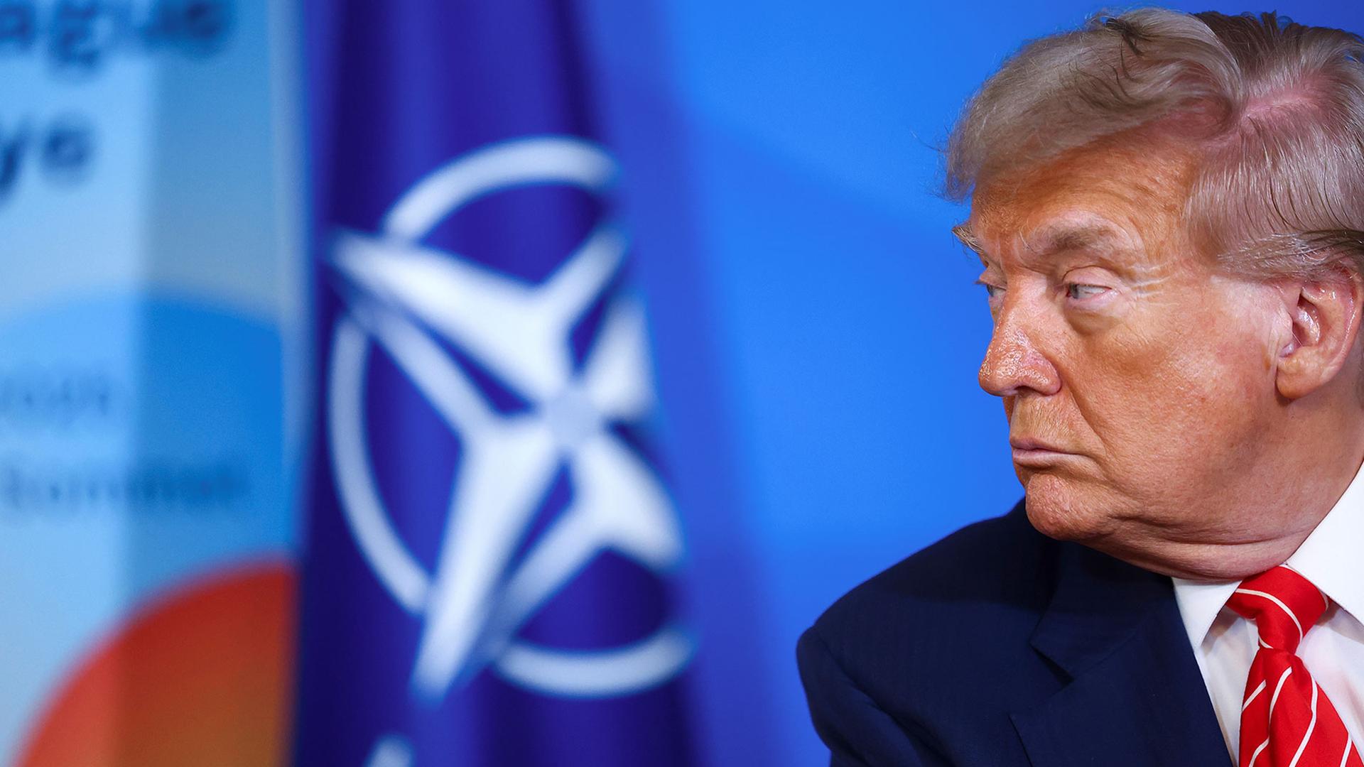 US-Präsident Donald Trump ist vor dem Logo der Nato zu sehen. 