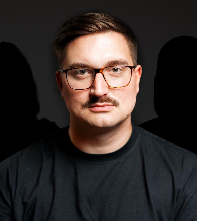 Ein Mann mit Brille und Schnurrbart im Porträt. Hinter ihm sind zwei Schatten zu sehen.