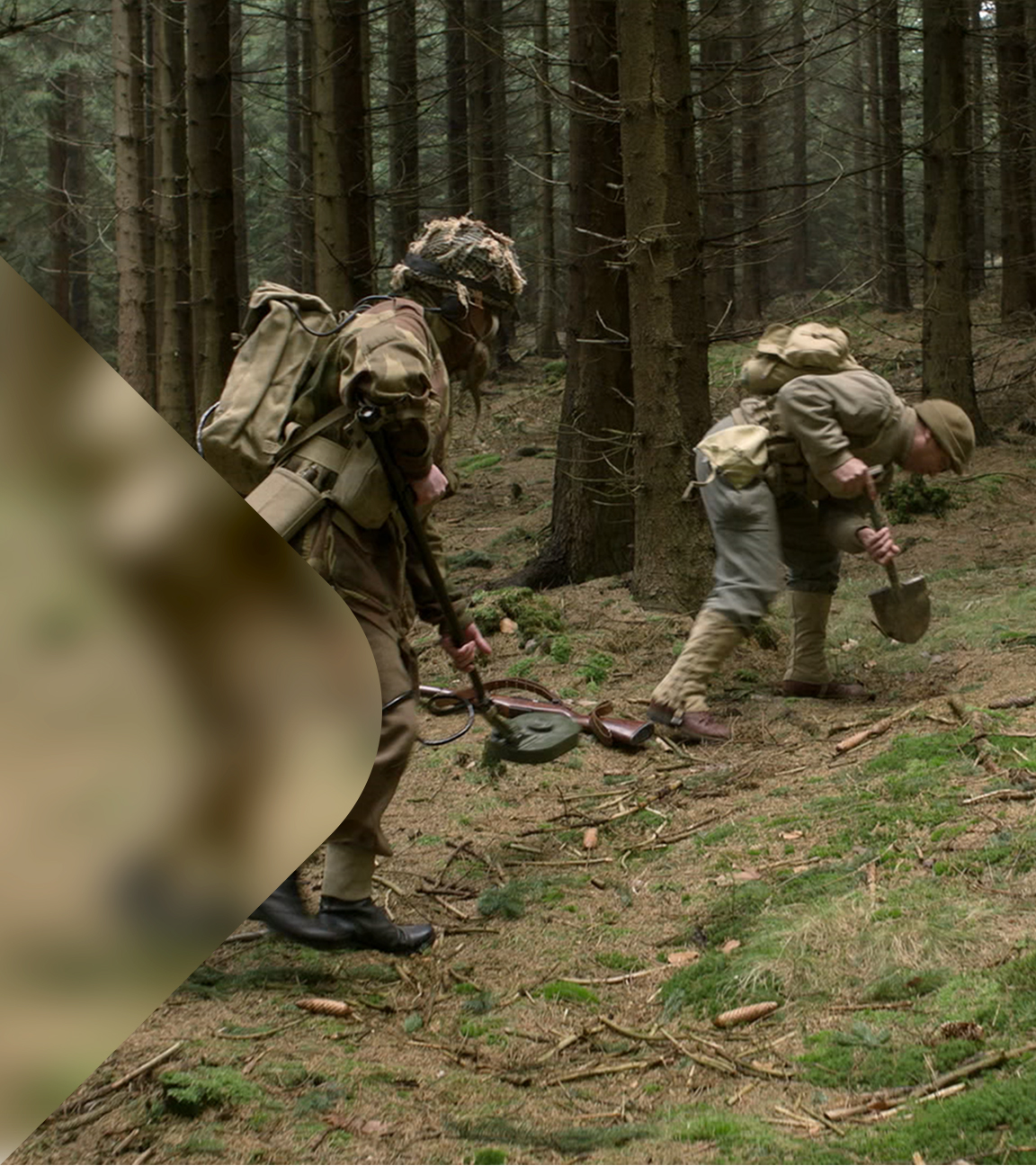 Zwei Männer in Armeekleidung suchen etwas mit Spaten im Wald.