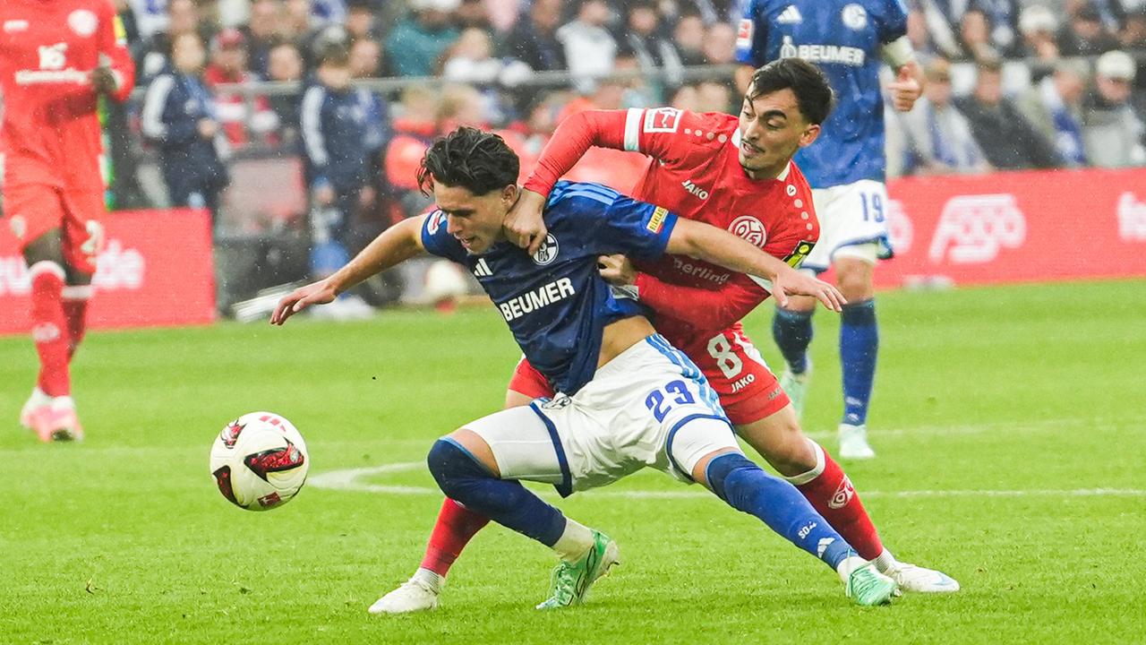 Der Mainzer Offensivspieler Paul Nebel reißt im Zweikampf seinen Schalker Gegenspieler Soufiane El-Faouzi zu Boden 