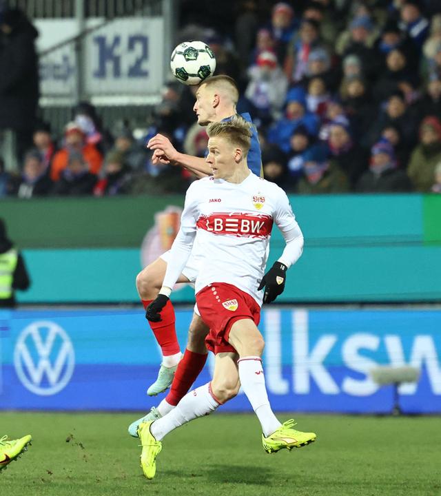 Im DFB-Pokal Viertelfinale kann sich Holstein Kiels Innenverteidiger Ivan Nekic im Zweikampf mit Stuttgarts Flügelspieler Chris Führich per Kopfball durchsetzen