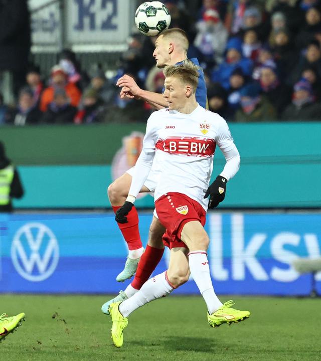 Im DFB-Pokal Viertelfinale kann sich Holstein Kiels Innenverteidiger Ivan Nekic im Zweikampf mit Stuttgarts Flügelspieler Chris Führich per Kopfball durchsetzen