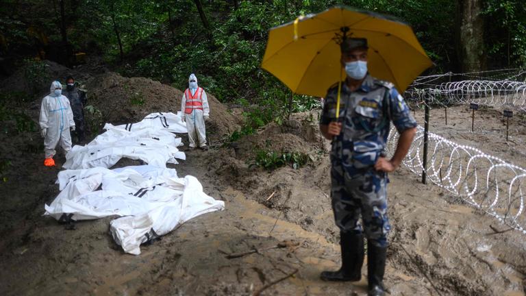 Sicherheitskräfte stehen am 1. September 2026 neben nicht identifizierten Leichen von Flutopfern, die im Waldreservat Gokarna in Kathmandu für ein Massenbegräbnis aufgebahrt sind.