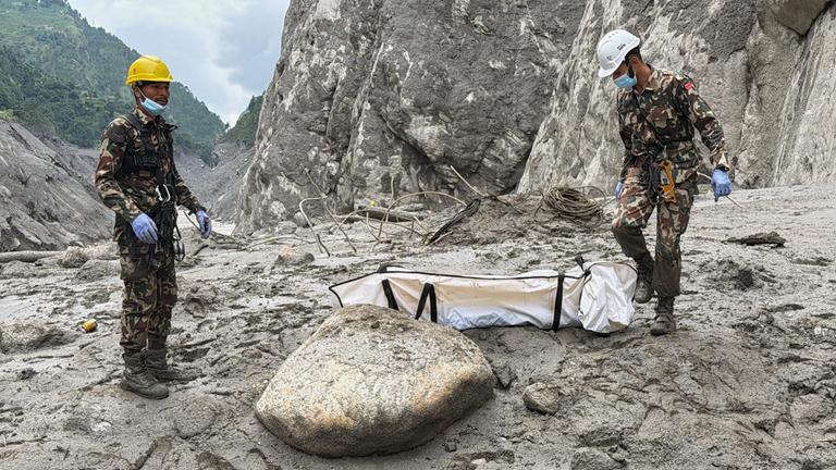 01.09.2026, Nepal, Upper Trishuli: Soldaten der nepalesischen Armee tragen die Leiche eines Arbeiters, die an der Baustelle eines Wasserkraftprojekts in Upper Trishuli, Nepal, geborgen wurde.