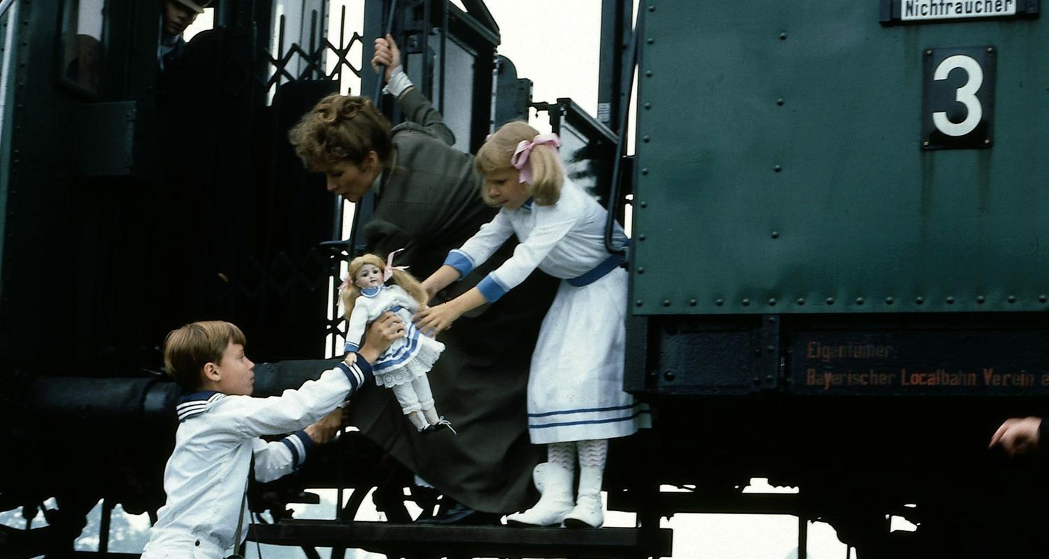 "Nesthäkchen - Teil 2": Klaus (Florian Baier) steht auf den Gleisen und reicht Annemarie (Kathrin Toboll) und Kindermädchen Lena (Susanne Uhlen) Annemaries Puppe.