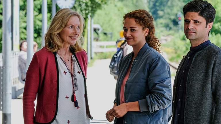 Auf dem Bahnsteig stehen Tanja Clemens (Therese Hämer), Julia Schindel (Oona Devi Liebich) und Tonio Niederegger (Maximilian Grill) beieinander. Alle drei lächeln.