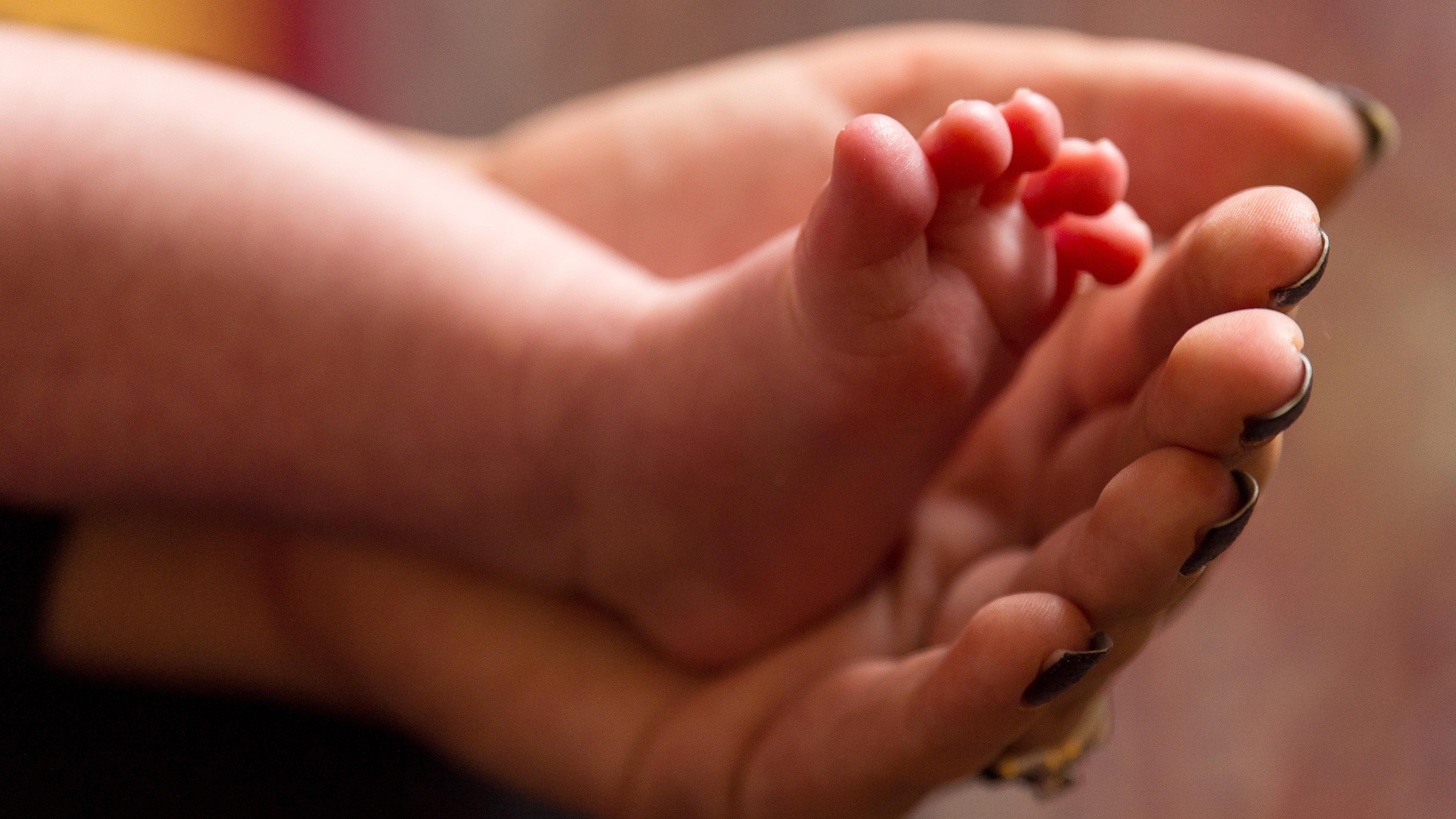 Mutter hält die Füße ihres Neugeborenen, aufgenommen am 9.04.2023 in Nord-England (Großbritannien)