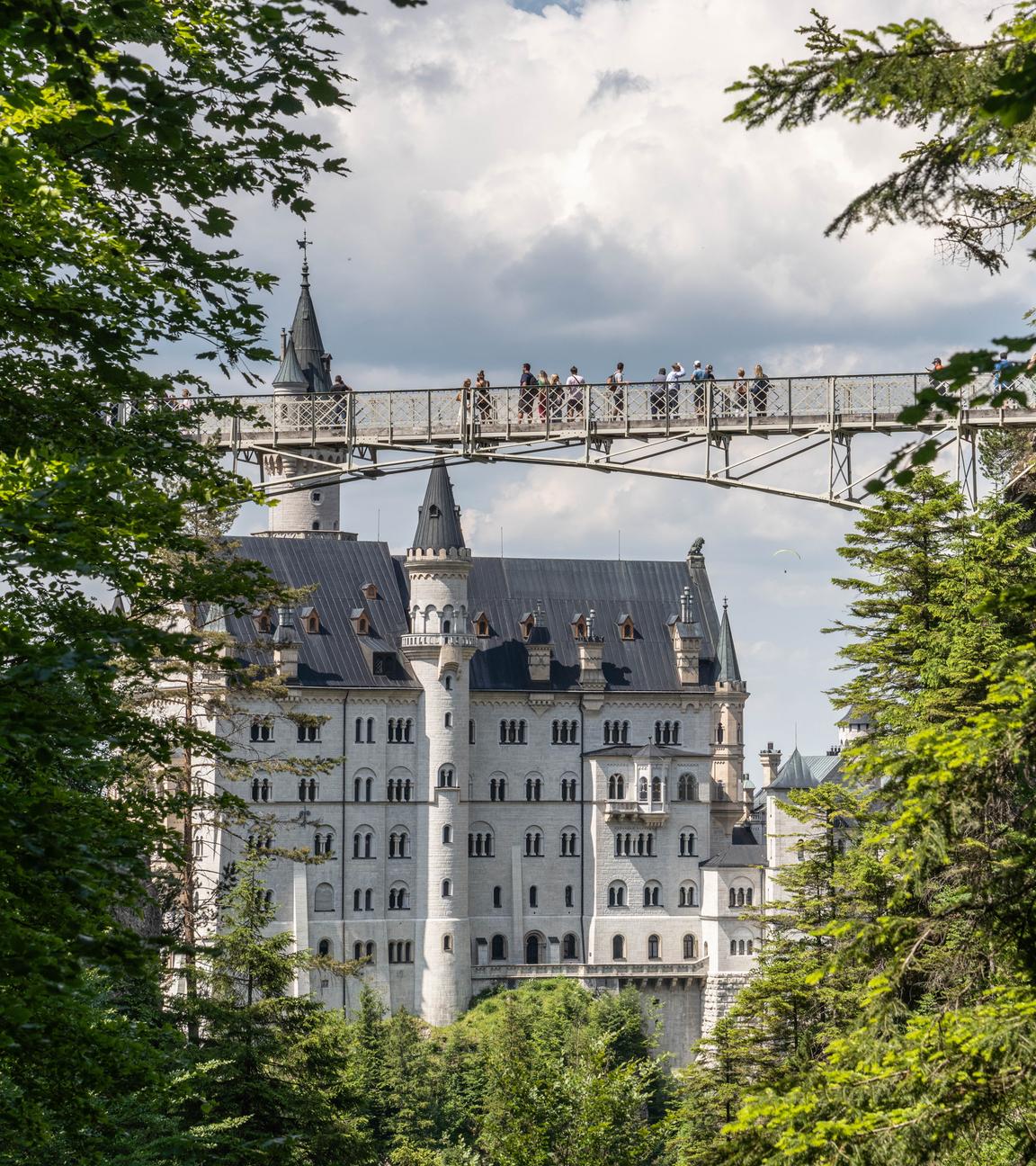 Zu sehen ist die Marienbrücke mit Menschen; im Hintergrund Schloss Neuschwanstein.