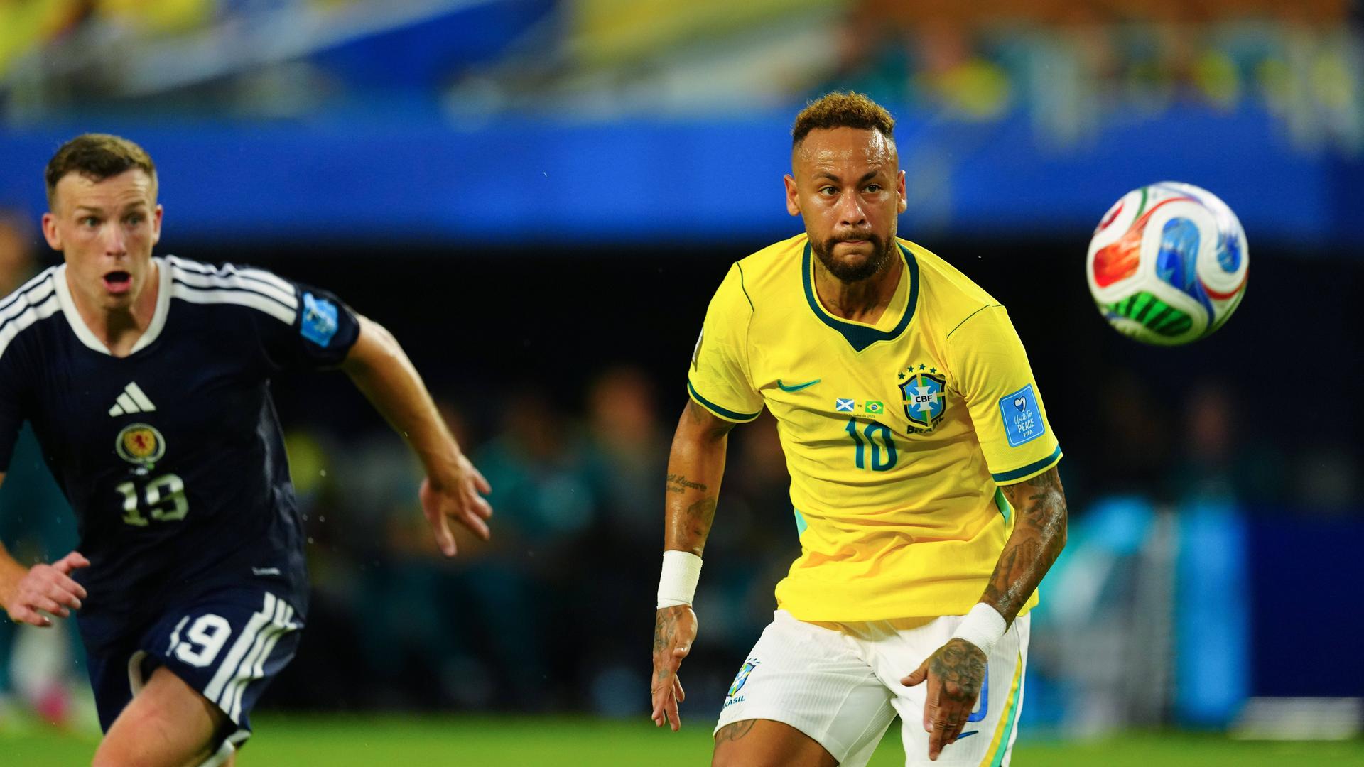 Der brasilianische Nationalspieler Neymar wird von seinem schottischen Kontrahenten Lewis Ferguson verfolgt