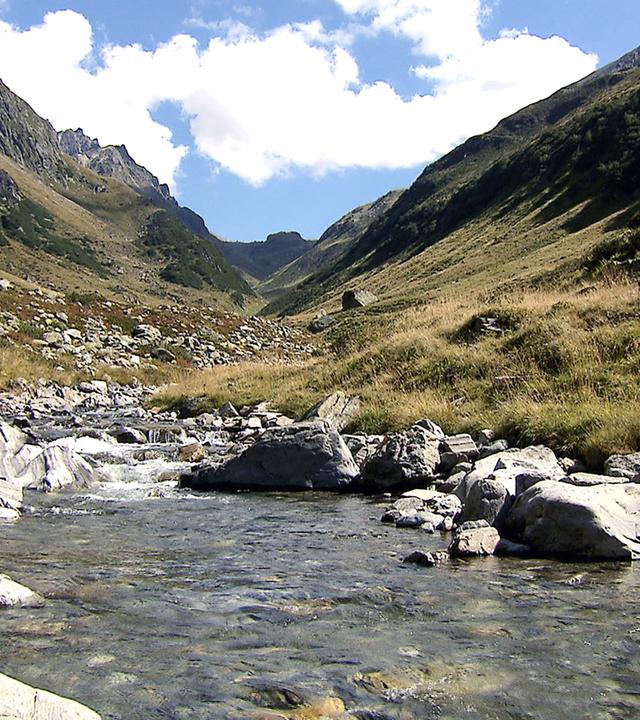 Gebirgsbach mit großen Steinen vom Wasser aus gesehen