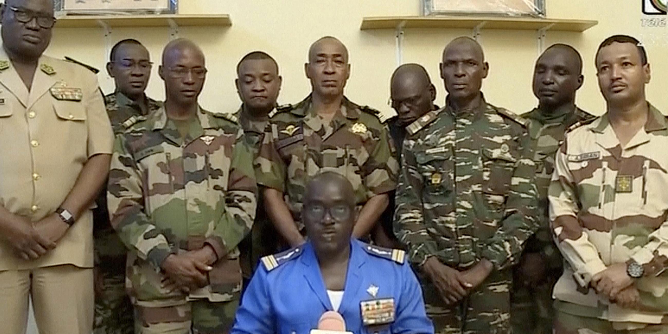 Oberstmajor Amadou Abdramane (vorne, M) am späten Mittwoch eine Erklärung ab, während eine Delegation von Militäroffizieren im nigrischen Staatsfernsehen erscheint, um eine Reihe von Kommuniqués zu verlesen, in denen sie ihren Staatsstreich ankündigen.