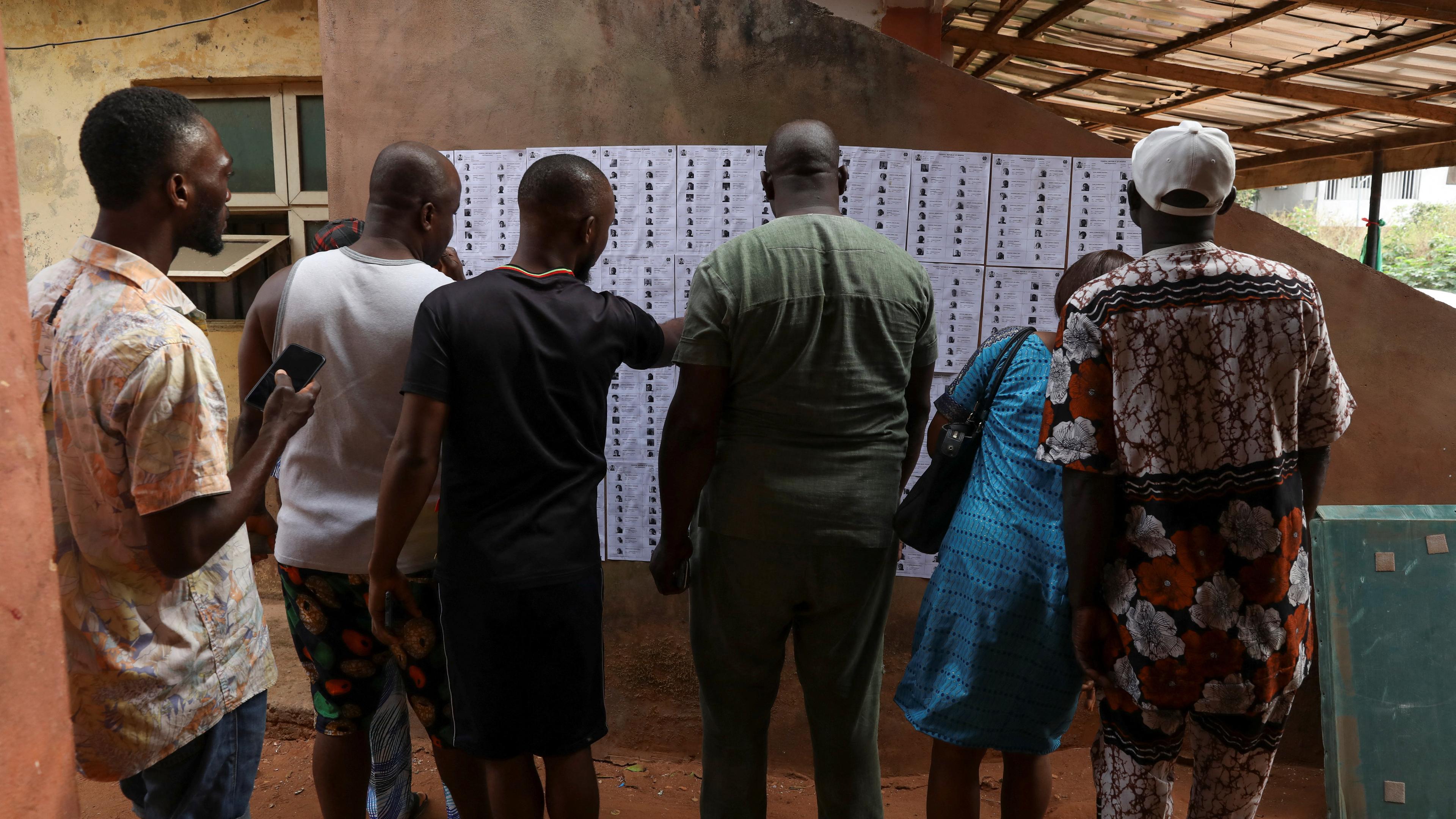 Menschen suchen nach ihren Namen auf den Wählerlisten vor der Parlaments- und Präsidentschaftswahl in Nigeria.
