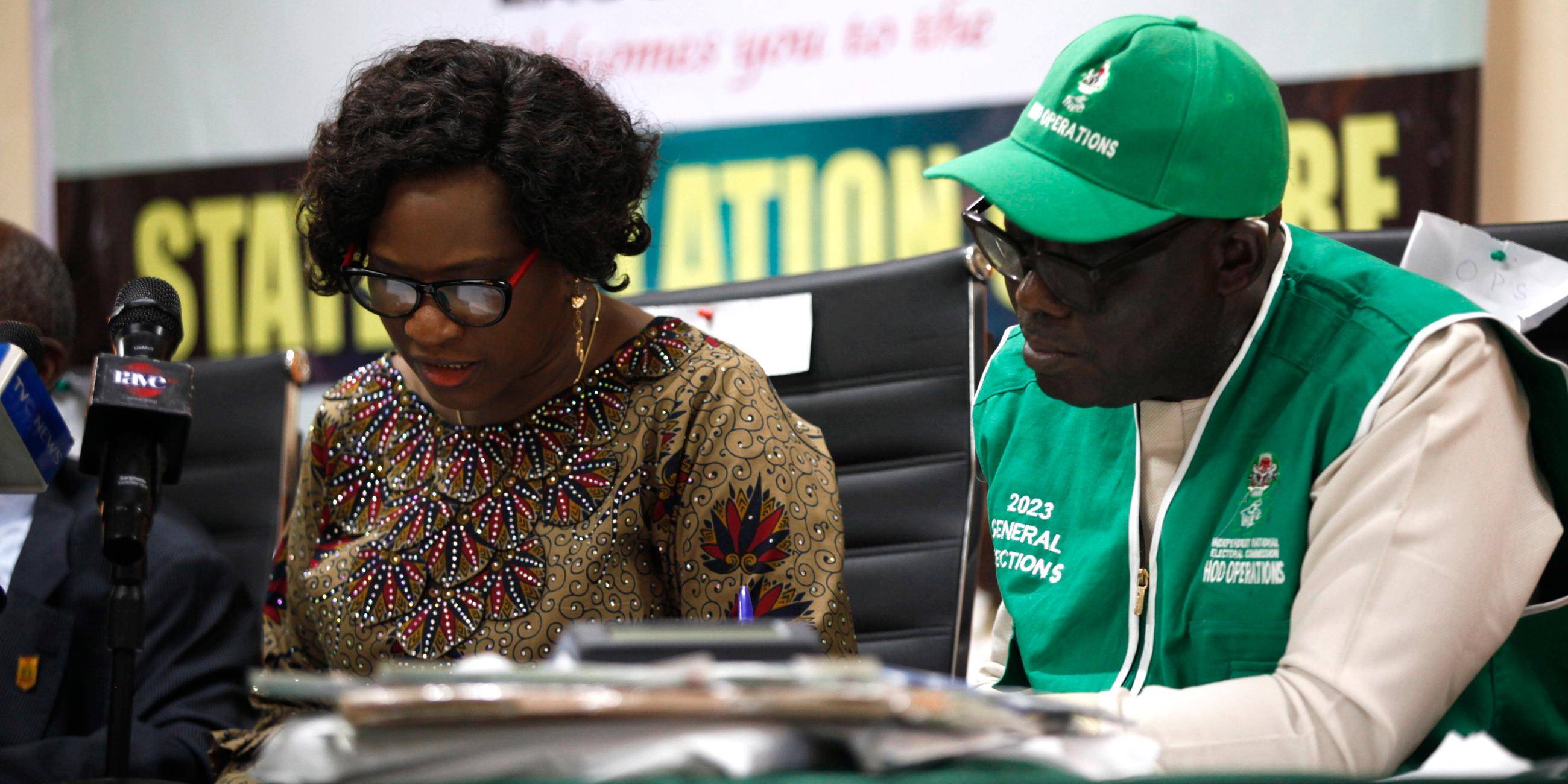 Zwei Personen arbeiten in einem Büro der Wahlkomission an einem Tisch.