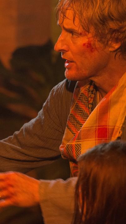 Hammond (Pierce Brosnan) und Jack Dwyer (Owen Wilson) stehen sich gegenüber. Jack packt Hammond verzweifelt am Arm.