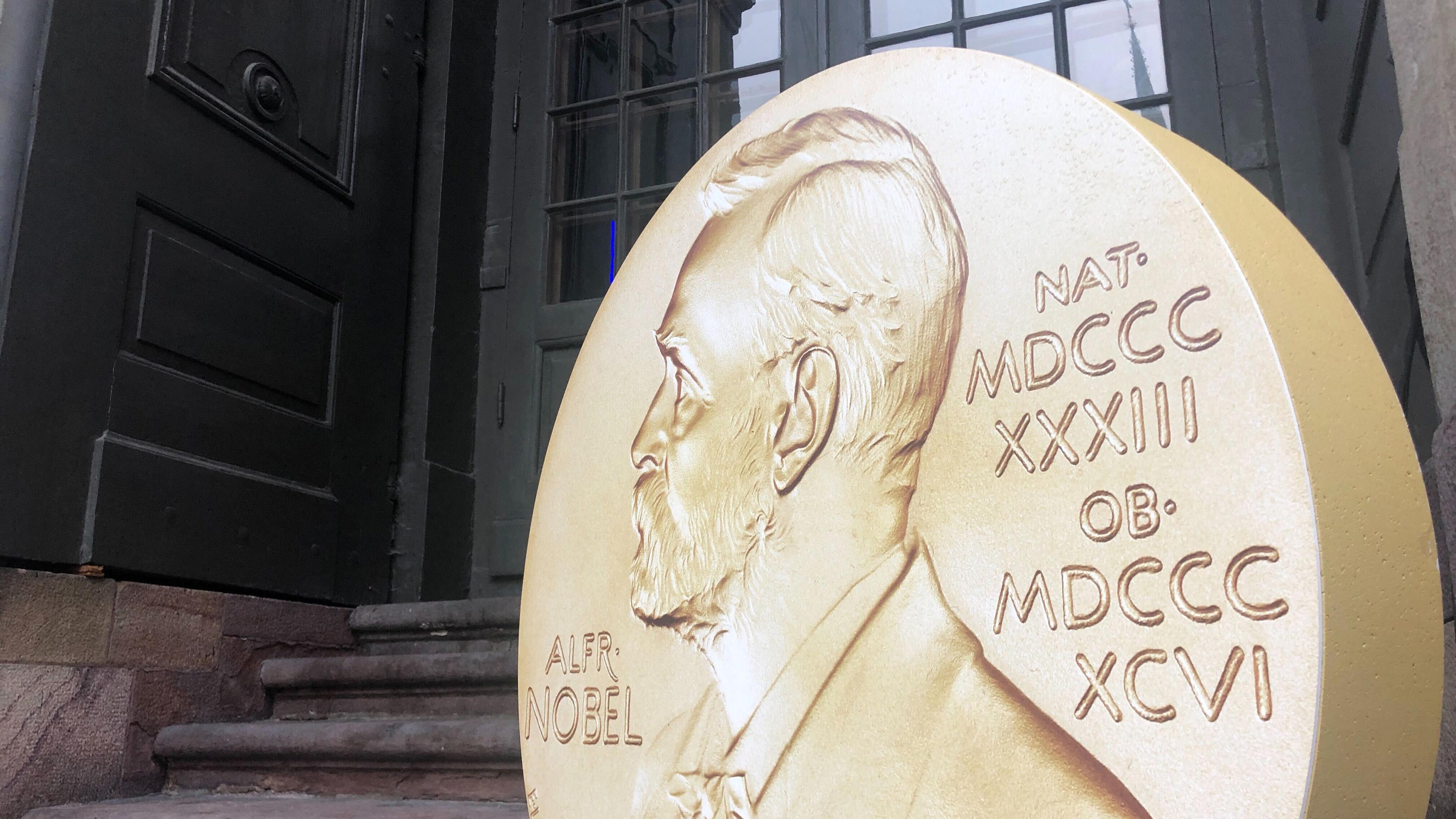 Symbolbild: Ein Aufsteller in Form der prestigeträchtigen Nobelmedaille weist vor dem Nobelpreismuseum in der  Altstadt Gamla Stan auf die Tage der Nobelpreis-Bekanntgaben hin.
