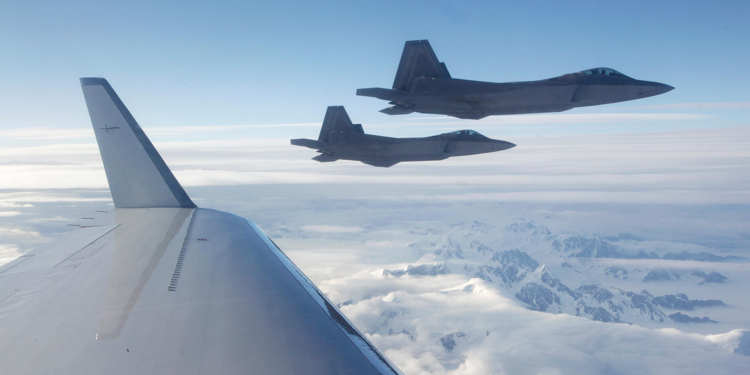 NORAD F-22-Kampfflugzeuge während einer Übung über einem bergigen Gebiet von Alaska