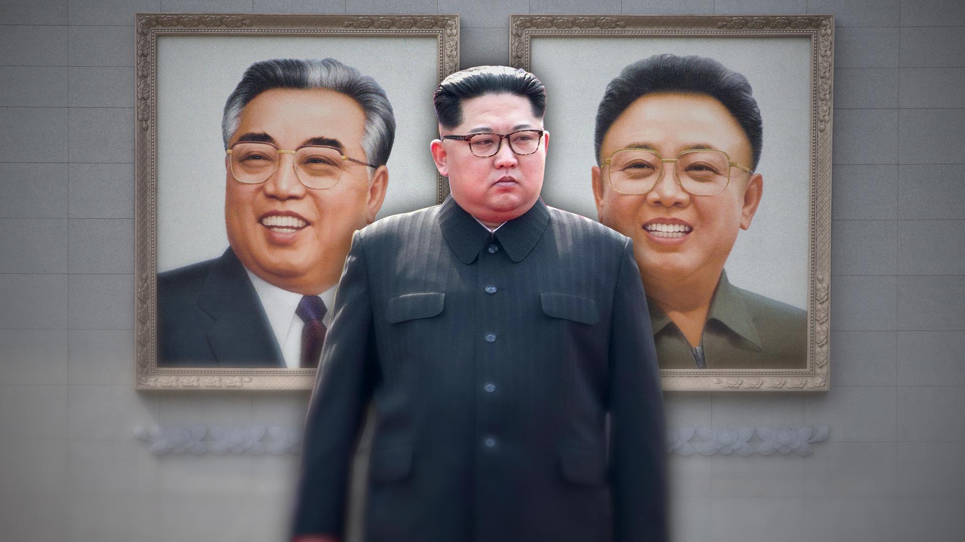 Kim Jong-un steht vor einer öffentlichen Mauer mit den großen Portraits seines Vaters und Großvaters.