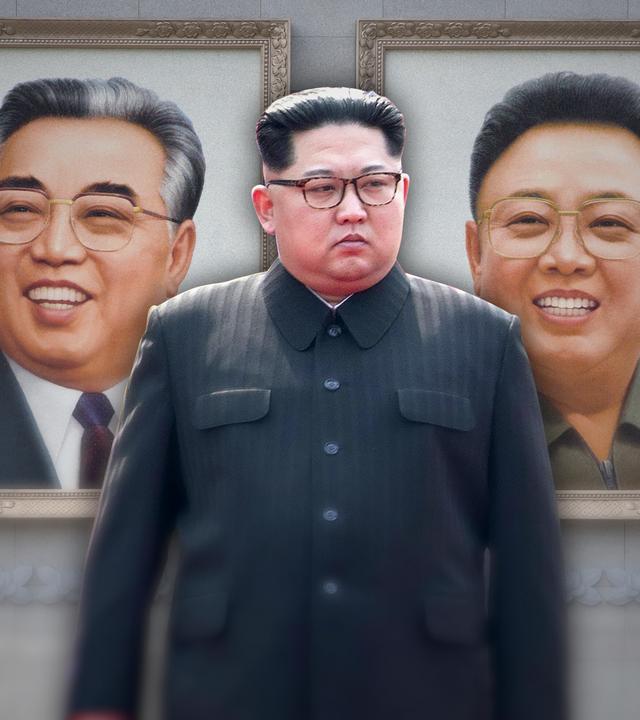 Kim Jong-un steht vor einer öffentlichen Mauer mit den großen Portraits seines Vaters und Großvaters.
