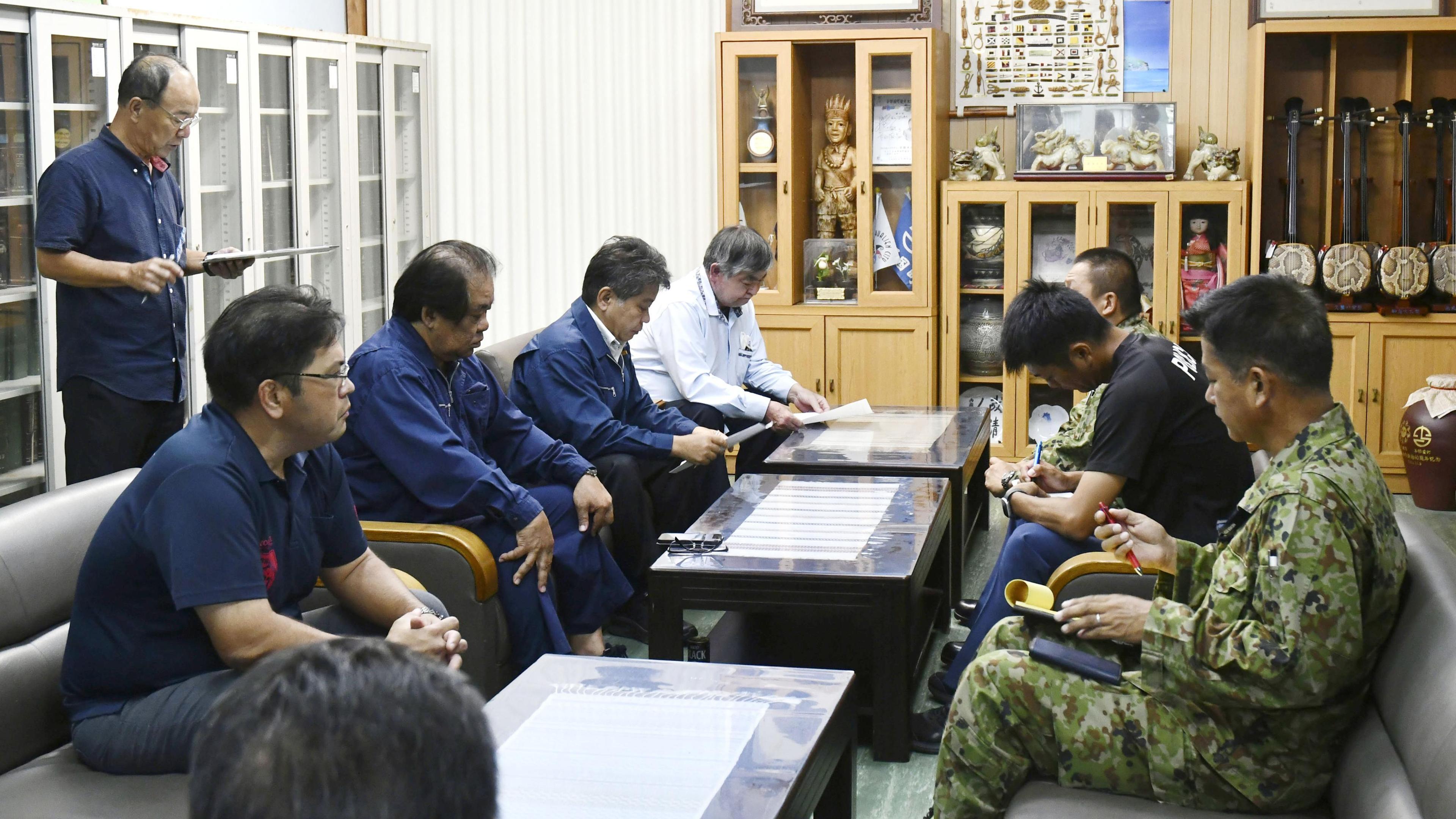 Lokale Beamte und Angehörige der japanischen Selbstverteidigungskräfte nehmen an einer Krisenkonferenz teil.