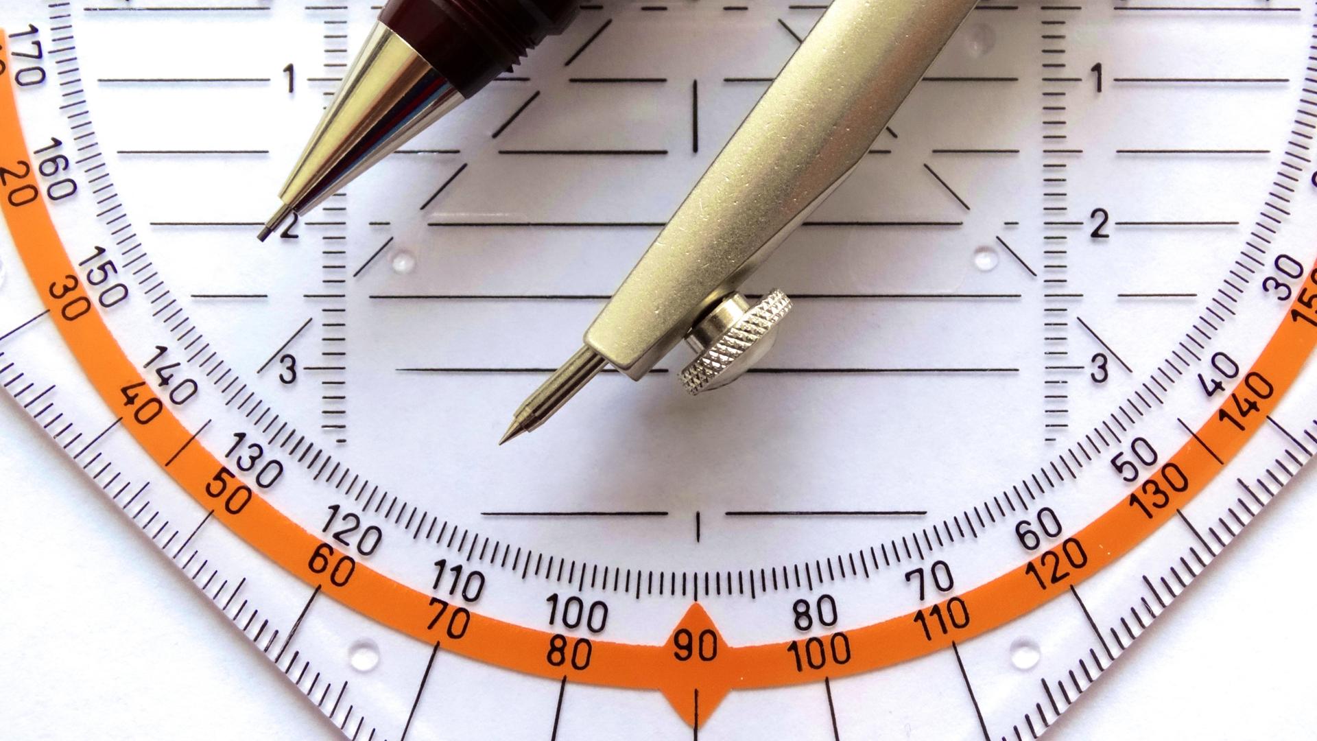 Nahaufnahme Geodreieck und Spitzen eines Zirkels