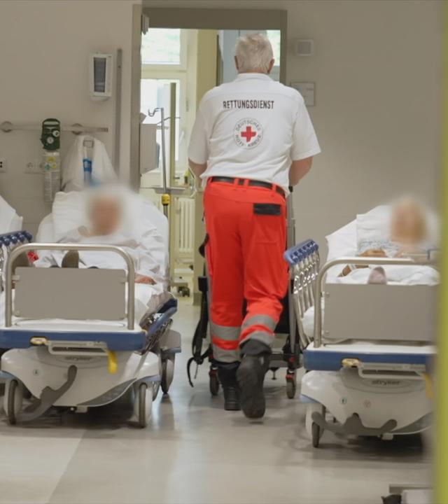 Zu sehen ist ein Raum in dem mehrere menschen in Krankenbetten liegen 