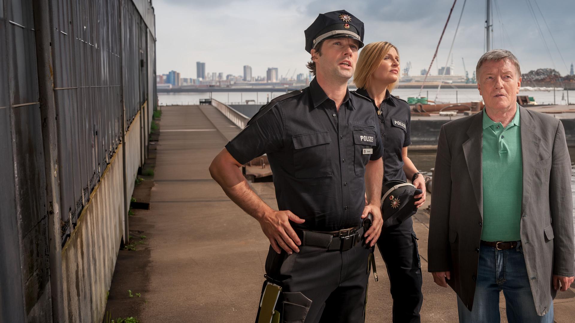 "Notruf Hafenkante - Abgetaucht": Mattes (Matthias Schloo) und Melanie (Sanna Englund) stehen mit Werner Grün (Manfred Zapatka) am Hafen. Sie schauen alle in die gleiche Richtung.