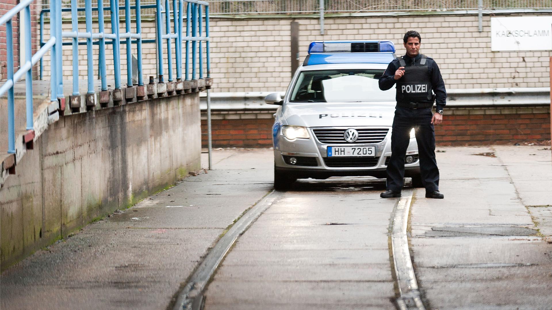 "Notruf Hafenkante - Recht und Gerechtigkeit": Tarik (Serhat Cokgezen) steht mit vorgehaltener Waffe, einsatzbereit vor dem Polizeiwagen.