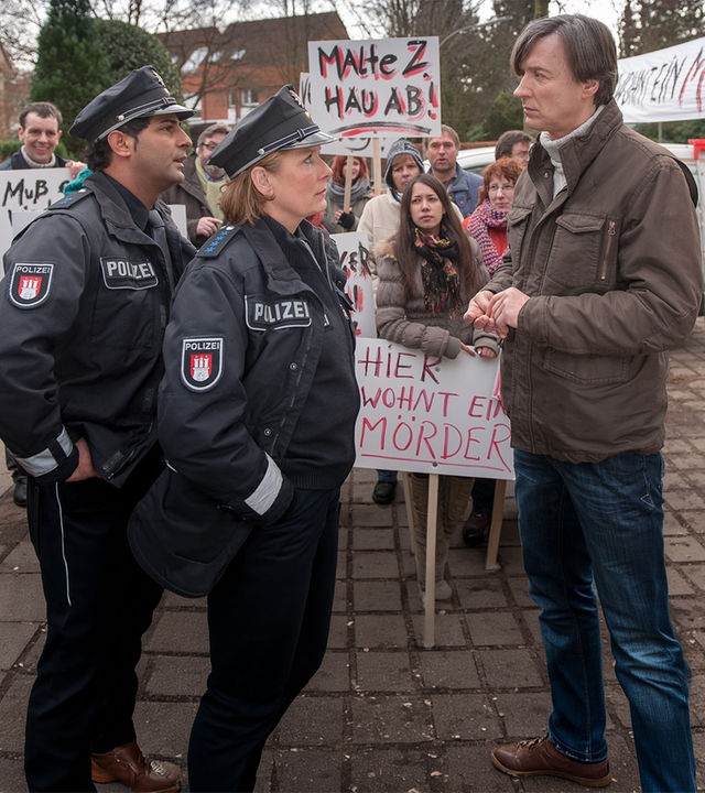 Bäckermeister Mittelbach (Martin Armknecht, r.) ist das Sprachrohr eines aufgewühlten Mobs gegen die Unterbringung des Gewaltstraftäters Zühl in ihrer Nachbarschaft. Claudia (Janette Rauch) und Tarik (Serhat Cokgezen, l.) versuchen zu beruhigen. 