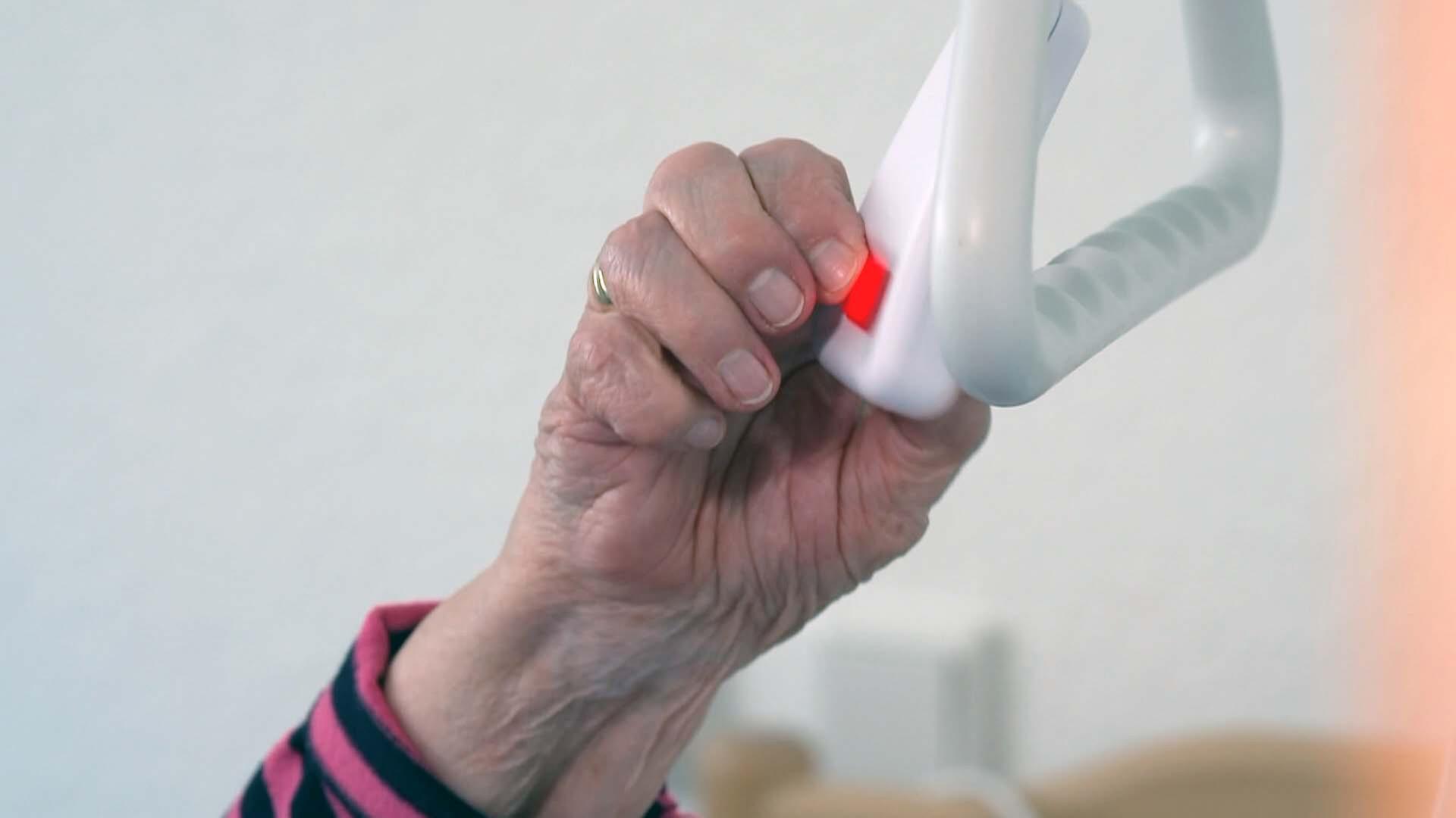 Hand drückt roten Notrufknopf