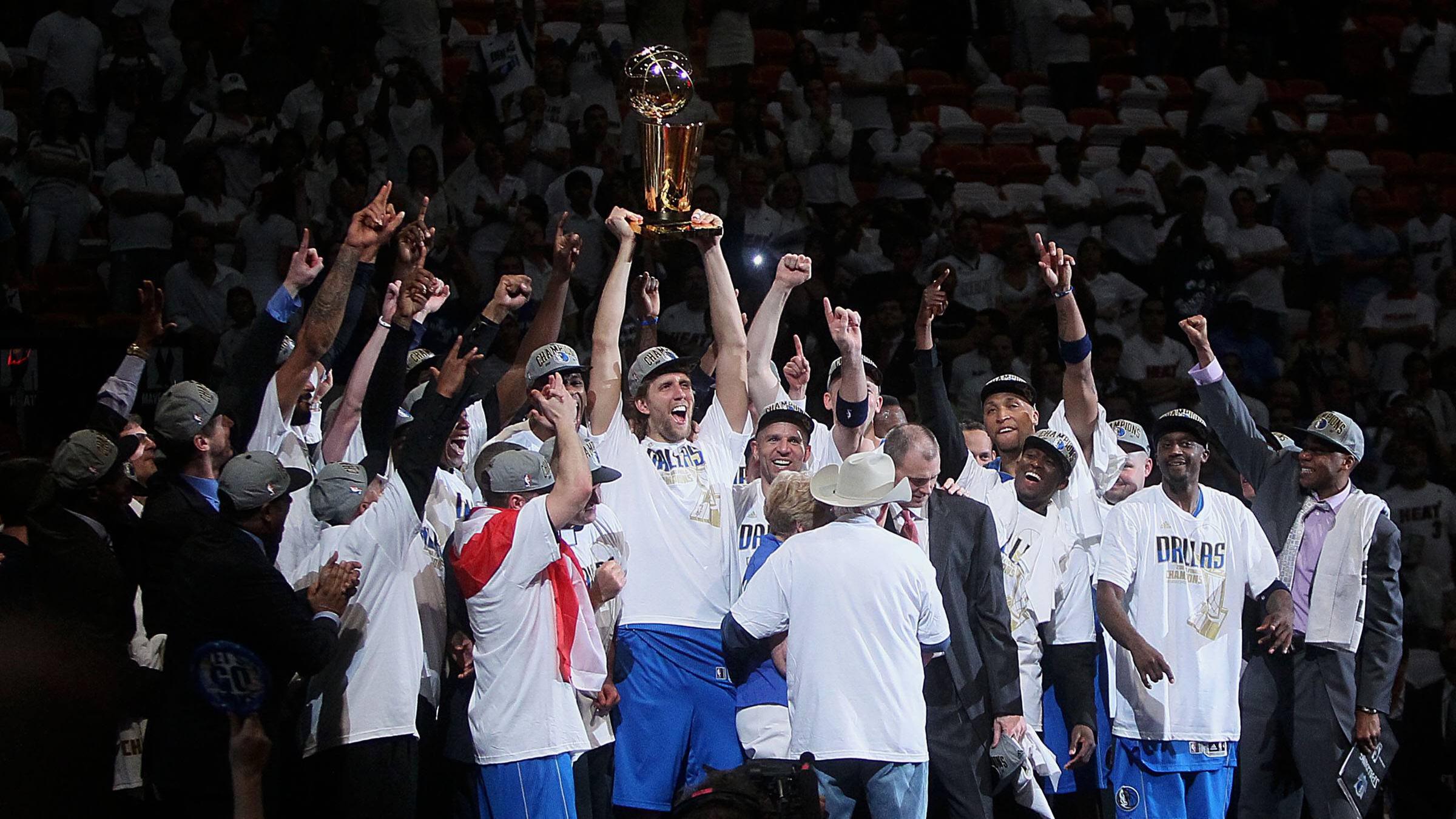 Dirk Nowitzki streckt umringt von den anderen Spielern der Mavericks den NBA-Pokal in die Höhe.