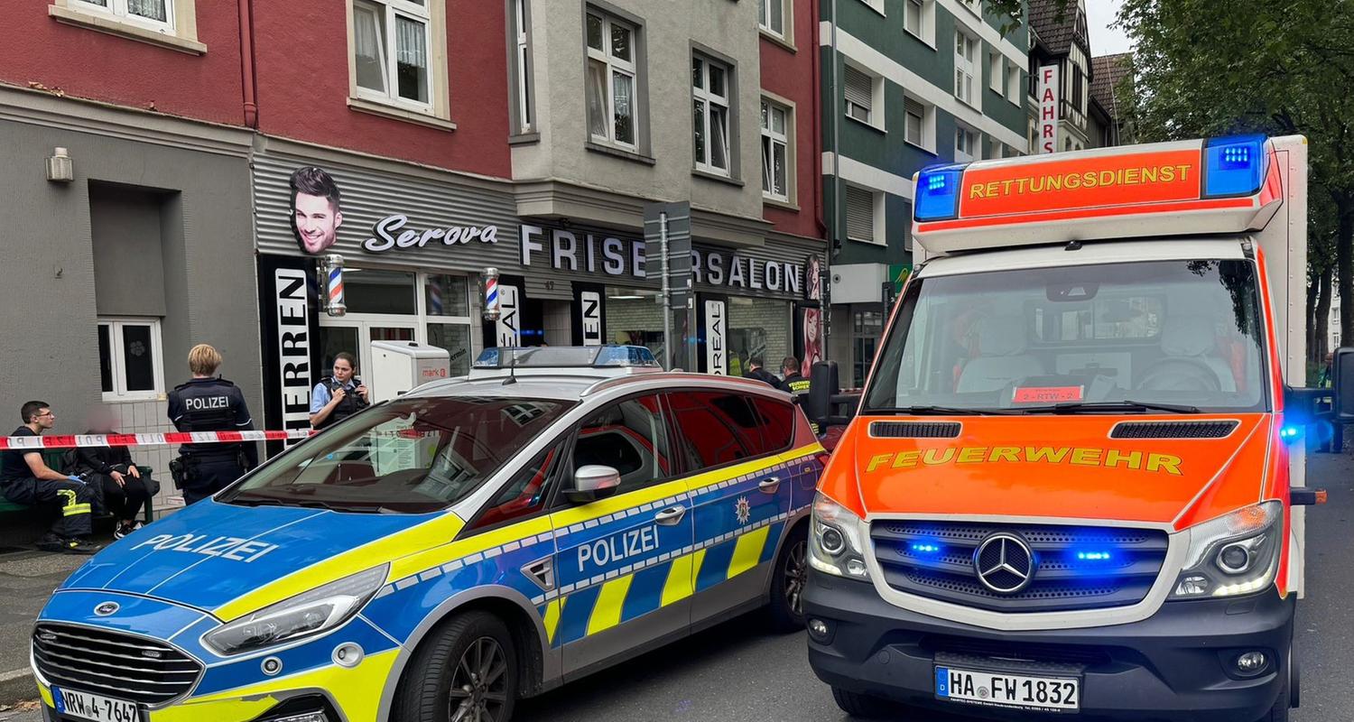 Nordrhein-Westfalen, Hagen: Ein Einsatzfahrzeug der Polizei und ein Rettungswagen der Feuerwehr stehen vor einem Friseursalon.