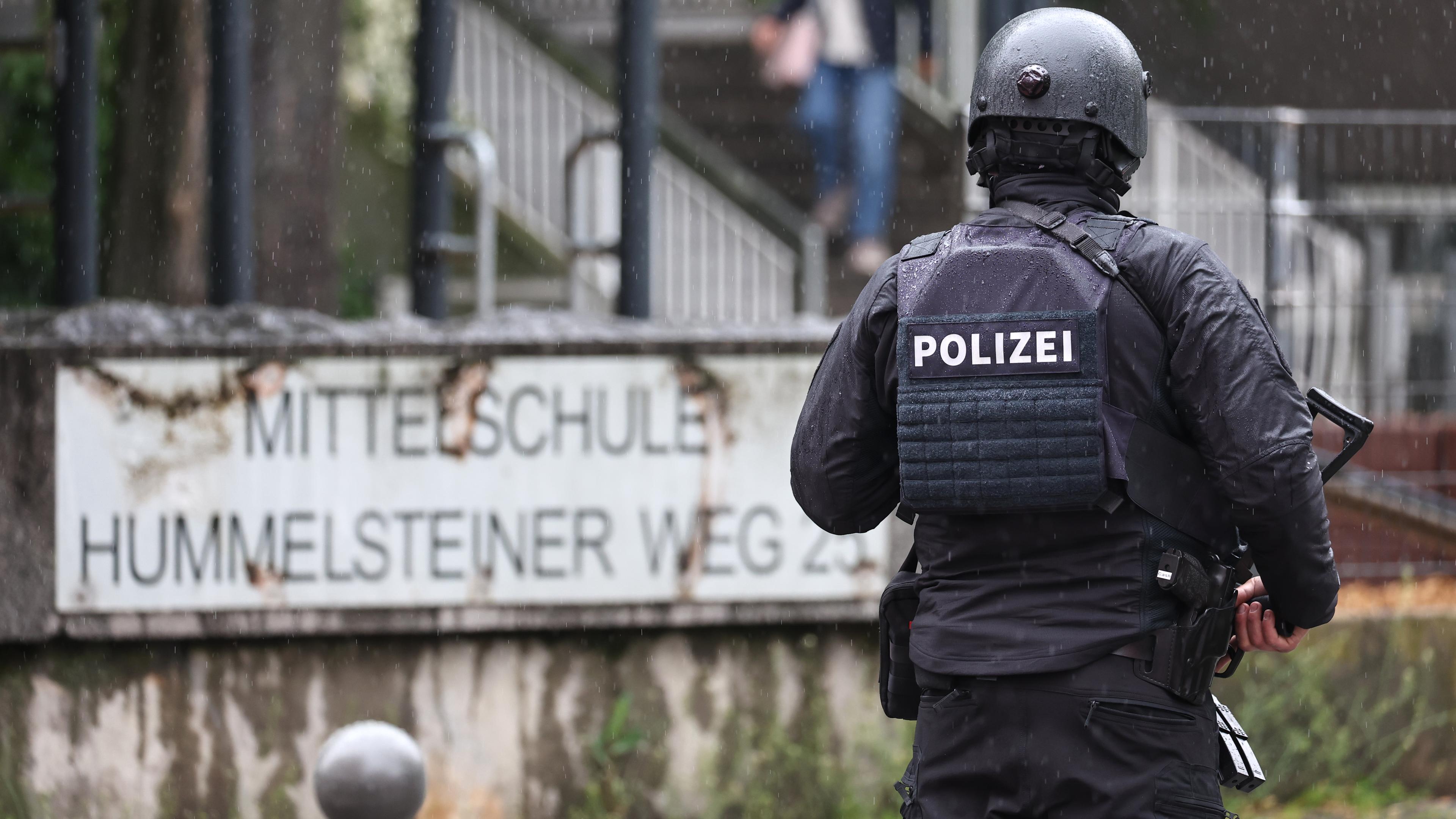 Ein Polizist steht vor der Schule in Nürnberg aufgrund eines Drohanrufs, aufgenommen am 10.05.2023