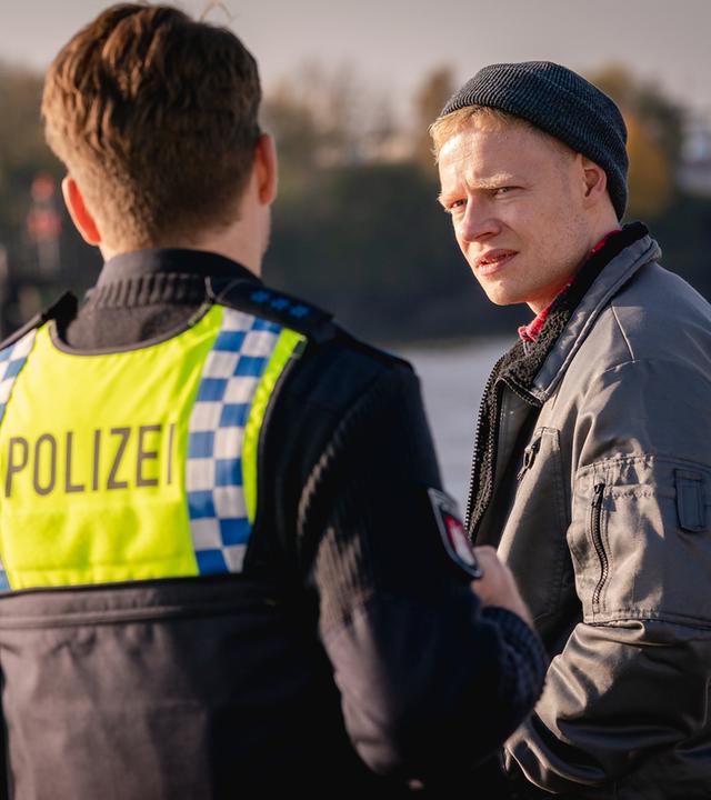 "Notruf Hafenkante - Nulllinie": Die Polizistin Franzi Jung (Rhea Harder-Vennewald) und ihr Kollege Nick Brandt (Raúl Richter) stehen nebeneinander vor Henner Schulte (Ilja Roßbander). Im Hintergrund ist die Elbe zu sehen.