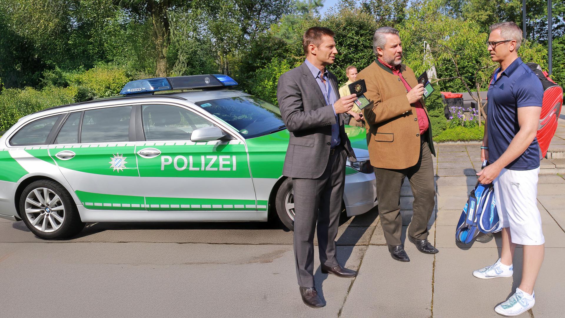 "Die Rosenheim-Cops - Nur Hansen war Zeuge": Vor dem Haus stehen am Polizeiwagen die Kommissare Hansen (Igor Jeftić), Stadler (Dieter Fischer) und Gerald Trettinger (Manou Lubowski).