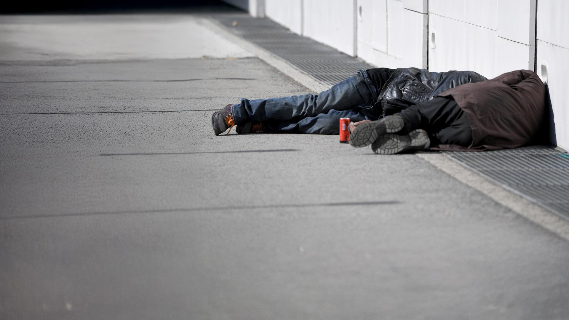 Zwei Obdachlose Männer schlafen auf der Straße.