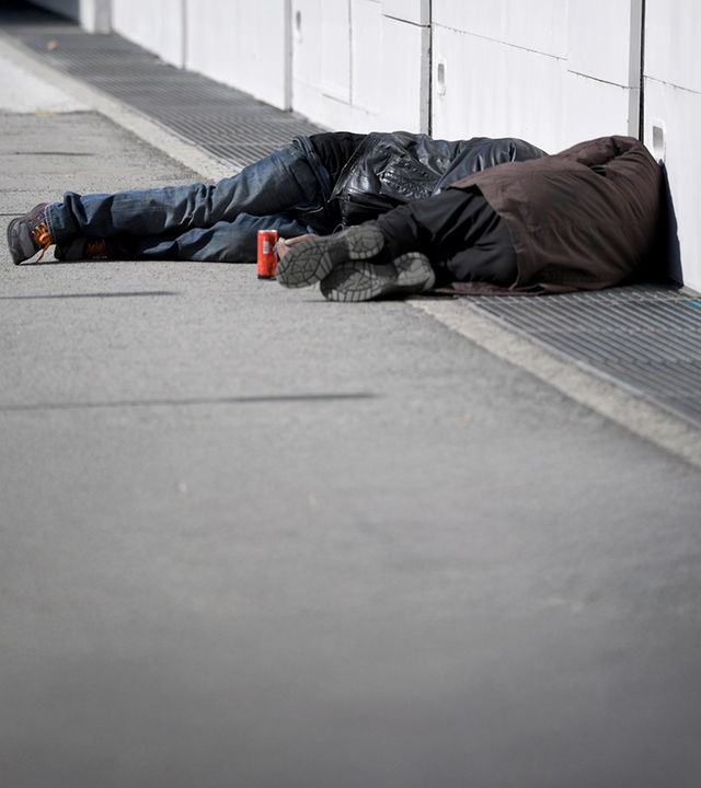 Zwei Obdachlose Männer schlafen auf der Straße.