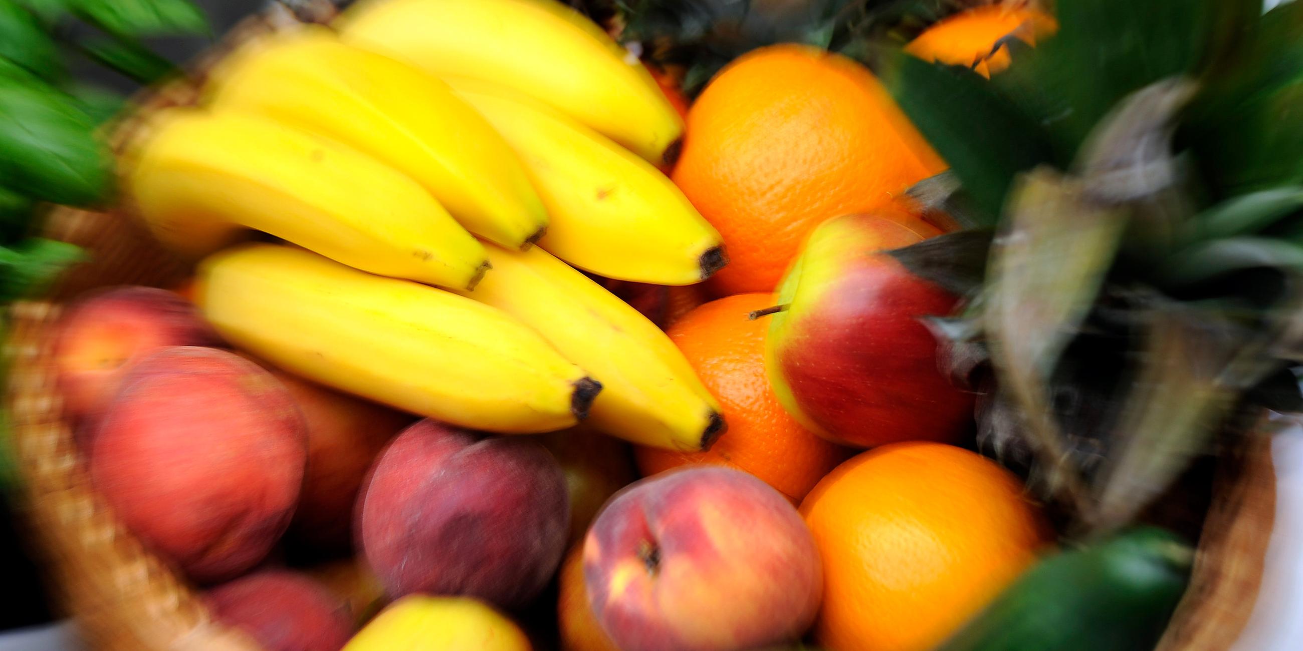 Ein Obstkorb mit Bananen, Äpfeln, Gurken, Orangen und Ananas, aufgenommen am 10.08.2013 beim «Vegan Street Day» in Dortmund (Nordrhein-Westfalen)
