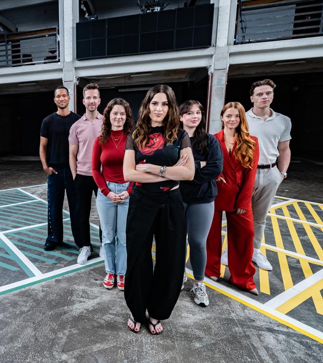 Die Gäste der Sendung stehen mit Moderatorin auf dem 13-Fragen-Spielfeld.