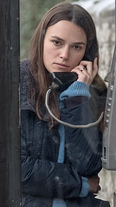 Katharine Gun (Keira Knightley) steht in einer halboffenen öffentlichen Telefonzelle und telefoniert.