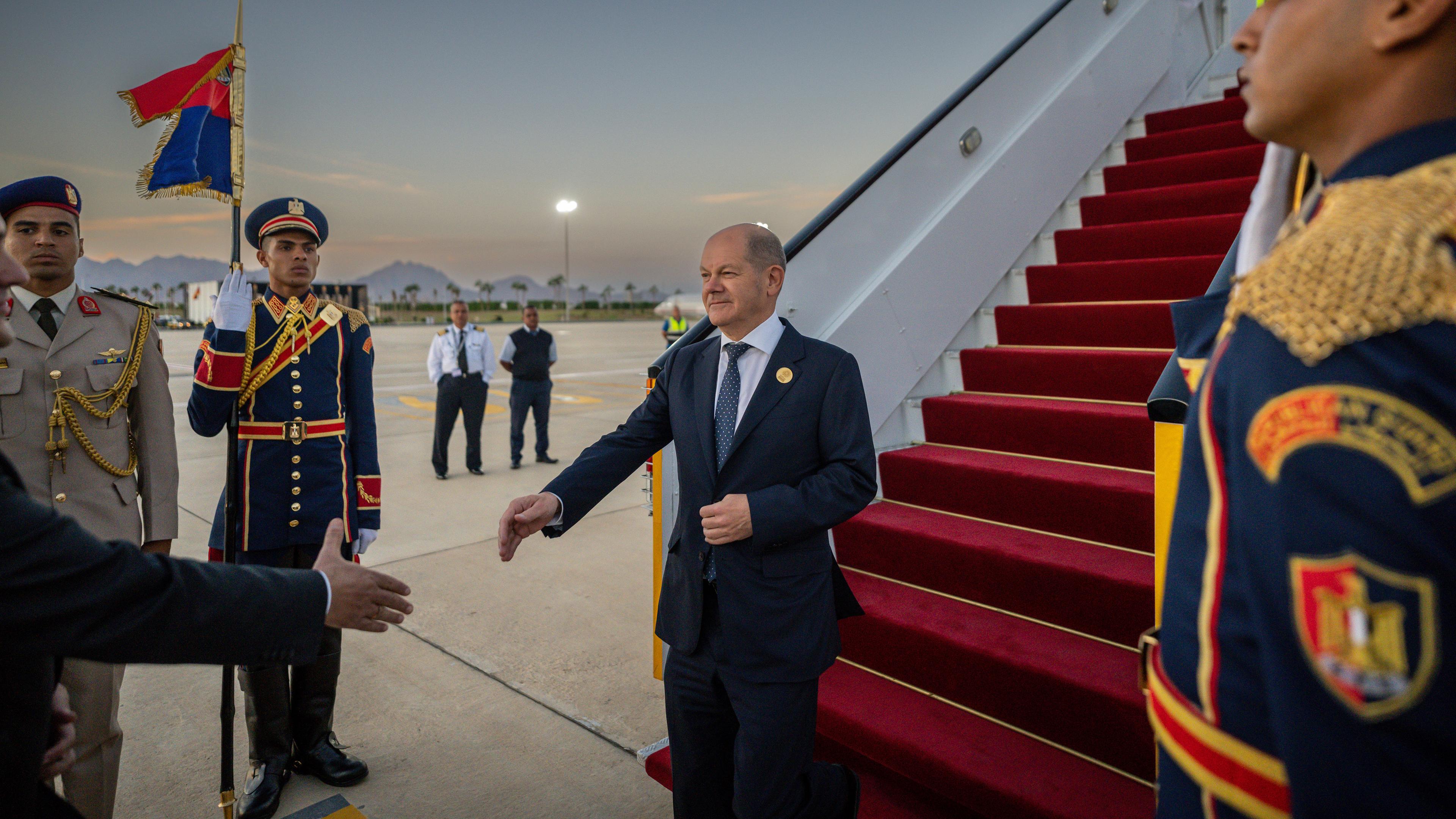 Ägypten, Scharm El Scheich: Bundeskanzler Olaf Scholz (SPD) wird bei seiner Ankunft auf dem Flughafen von einem Protokollmitarbeiter begrüßt.
