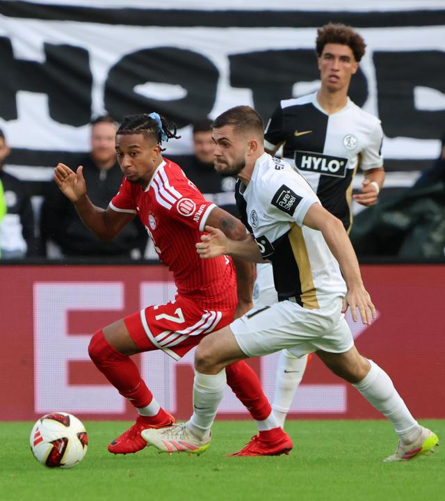 Bayerns Flügelspieler Michael Olise wird von seinen beiden Elversberger Kontrahenten Maurice Krattenmacher und Lukasz Poreba bedrängt