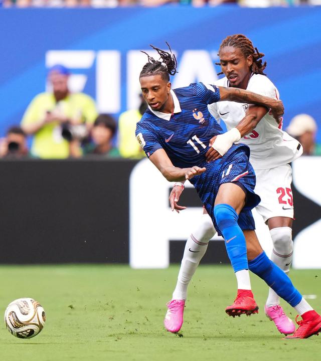 Der englische Nationalspieler Djed Spence umklammert im Zweikampf seinen französischen Kontrahenten Michael Olise