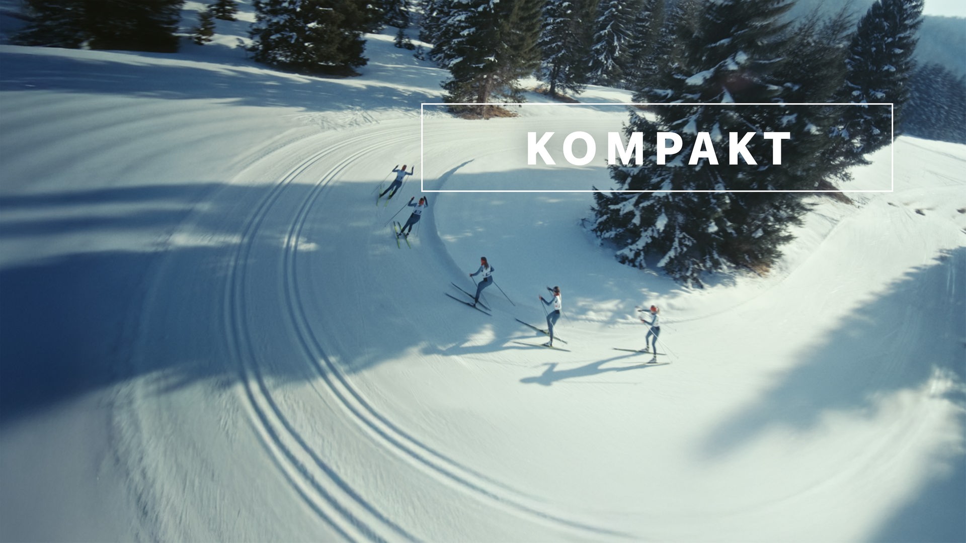 Das Wintersport "KOMPAKT"- Logo vor Langläufern auf der Strecke