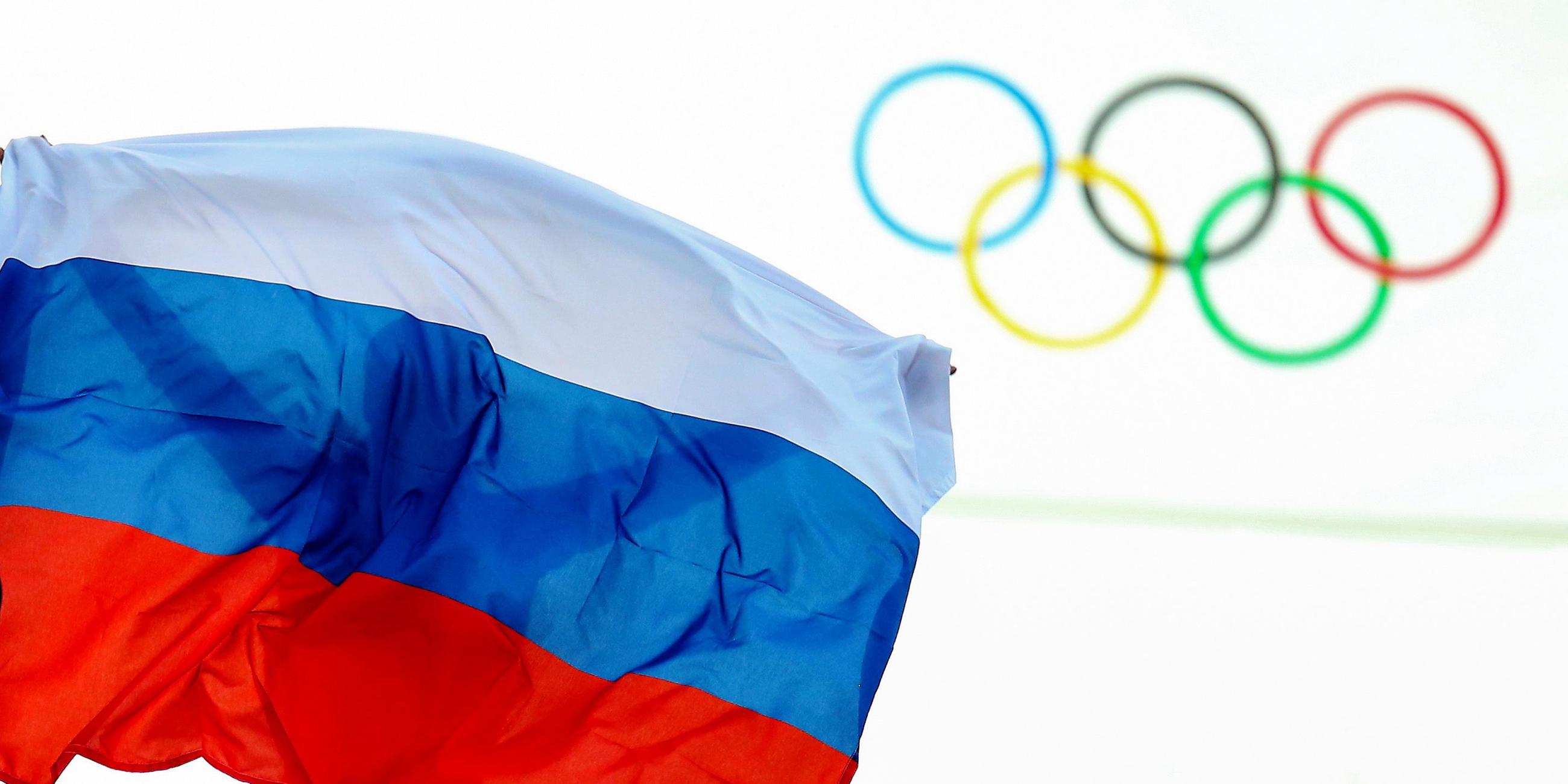 Ein Athlet aus Russland feiert mit einer Flagge nach einem Event bei den Olympischen Spielen 2014.